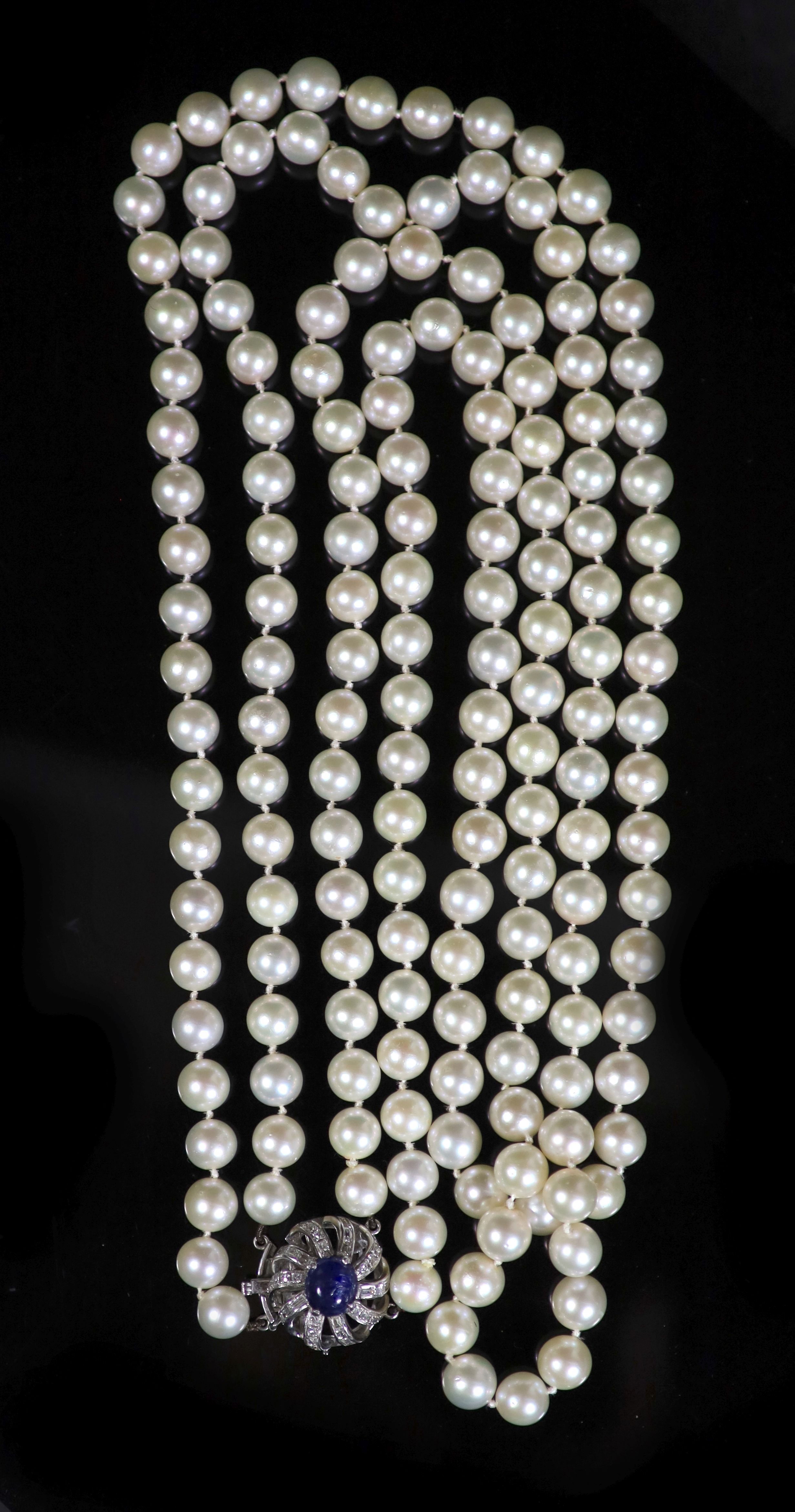 A two-row uniform cultured pearl necklace with 14K white gold, sapphire and diamond set flower clasp,